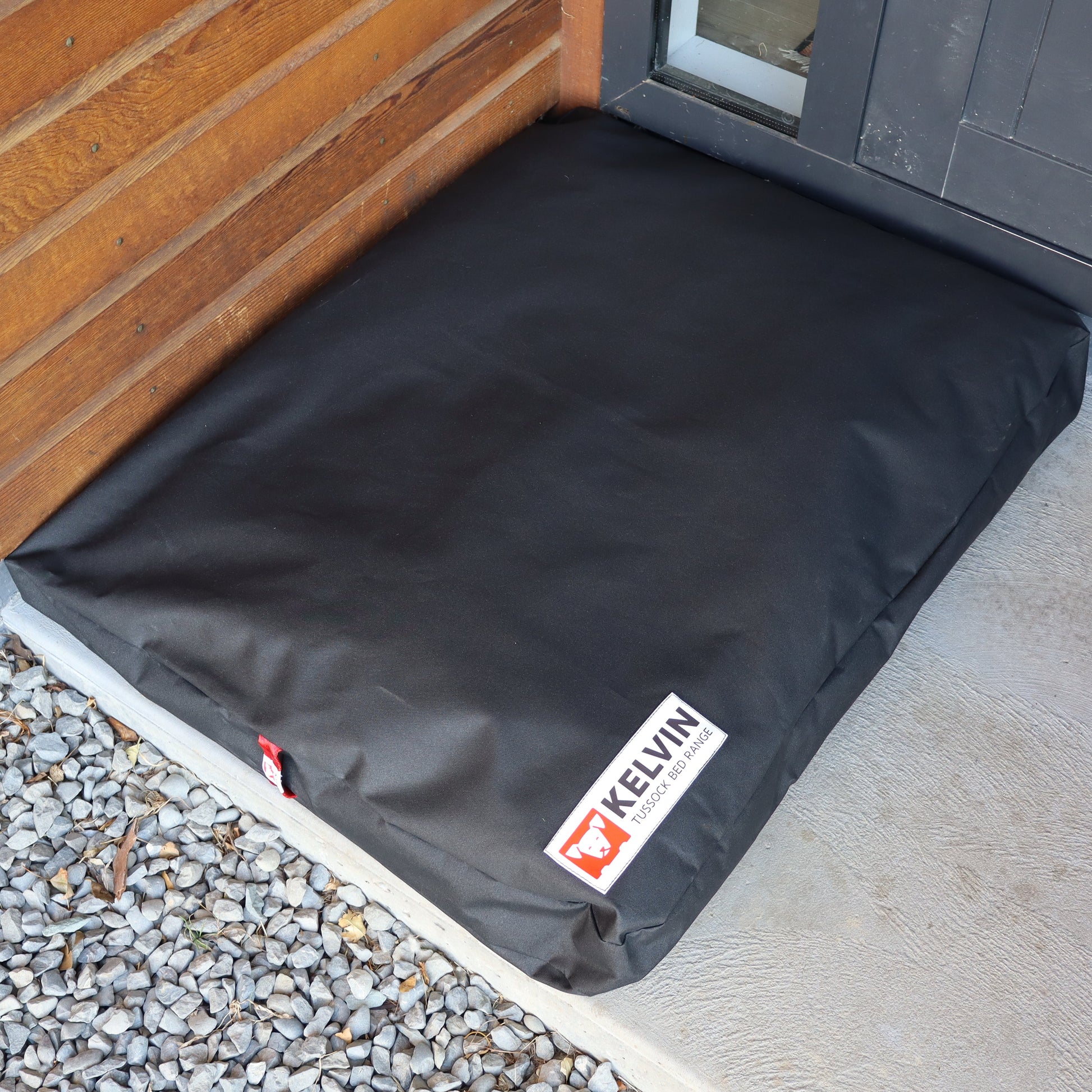 Large Tussock Dog Bed at backdoor made from black washable canvas outer and 100% NZ wool inner